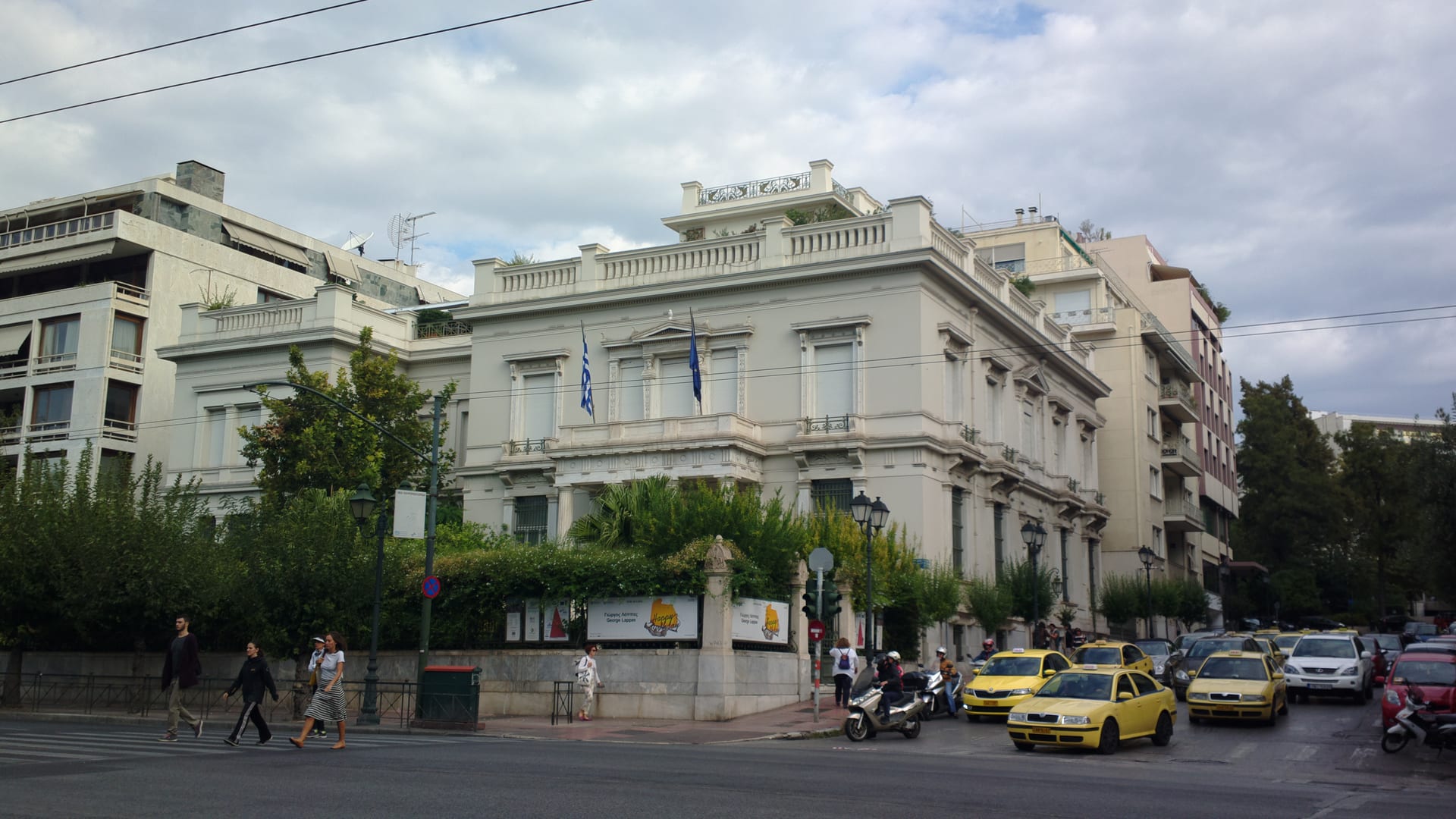 The neoclassical main building of the Benaki Museum of Greek Culture in central Athens, with Greek and EU flags at the entrance.